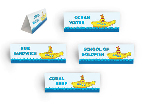 Add creativity to your Yellow Submarine food display with our food station signs. Tent-fold signs designed with a Yellow Submarine floating on blue water. Each sign measures 3 inches by 8 1/2 inches. Place your “Ocean Water” sign near your water bottles or bunch bowl. Place your “Sub Sandwich” sign near your sandwich and/or wrap section. Place your “School of Goldfish” near Goldfish-filled treat cups – how fun is that! Place your “Coral Reef” near your colorful salad and fruit display. tribegift.com