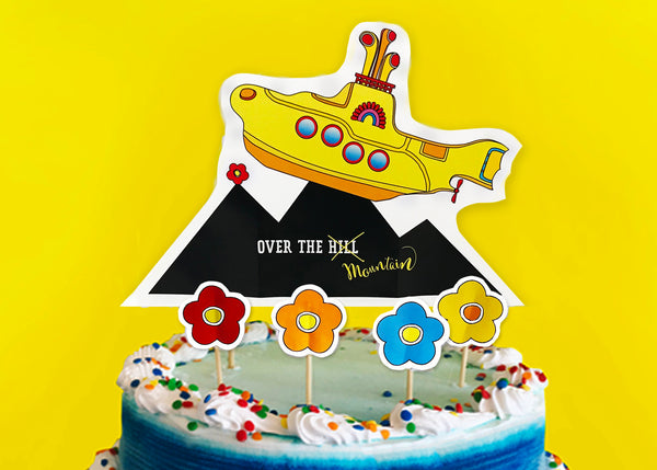 A bold and brave Yellow Submarine makes its way over the peak of a mountain within this cake topper.  This is no average “Over the Hill Party” experience. We are talking mountains - not hills. Cake topper showcases a yellow submarine making its way over a mountain peak. Four flower cake picks come with this cake topper. All picks are made out of 100% Natural Bamboo - biodegradable! - tribegift.com